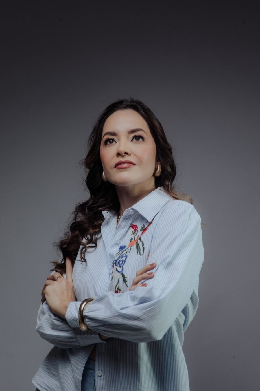 Dra. Dienifer de braços cruzados, olhando para cima